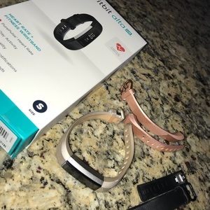 Fitbit Alta HR with gold, pink, and black bands.